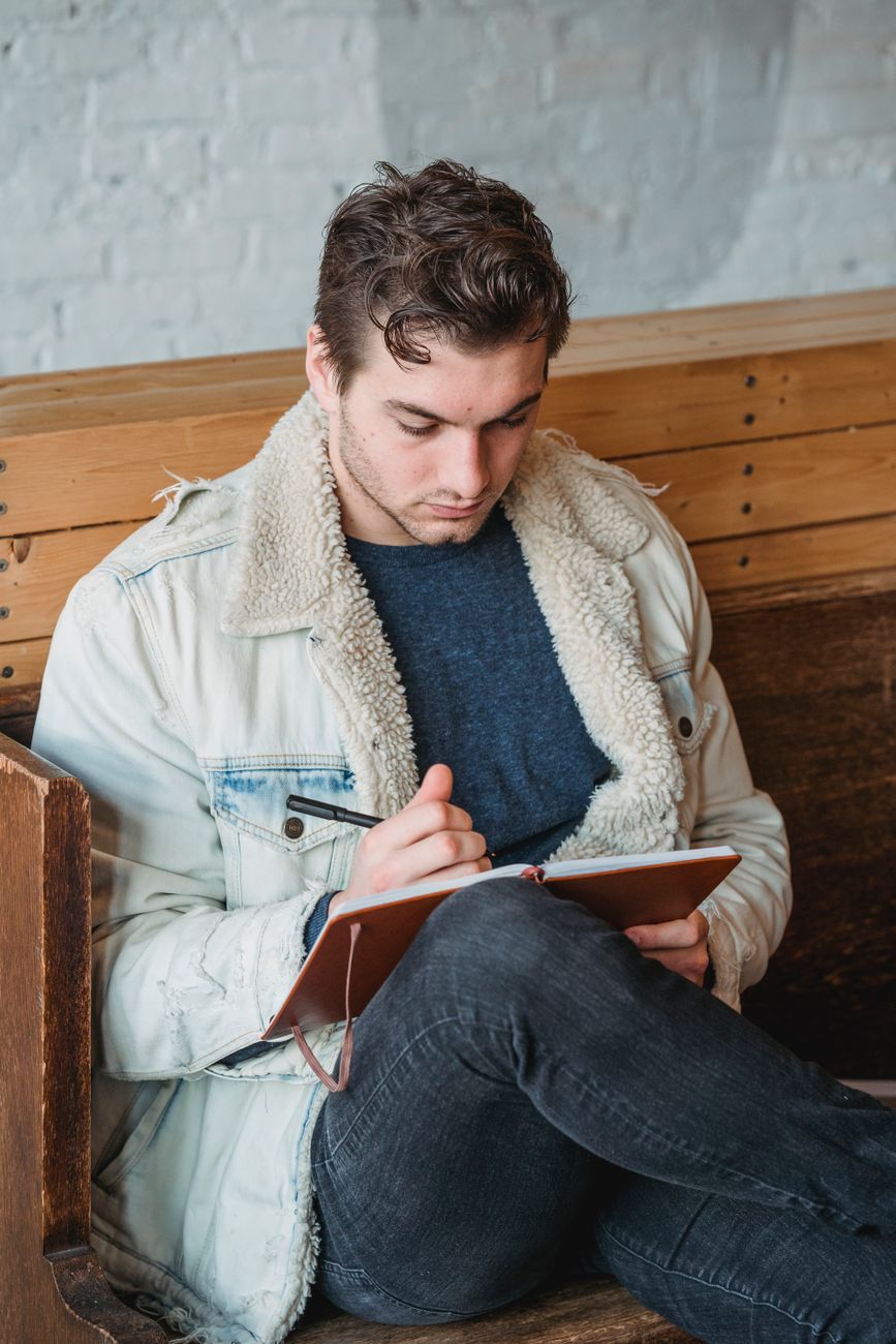 Travel journalist writing field notes on a mountain bench