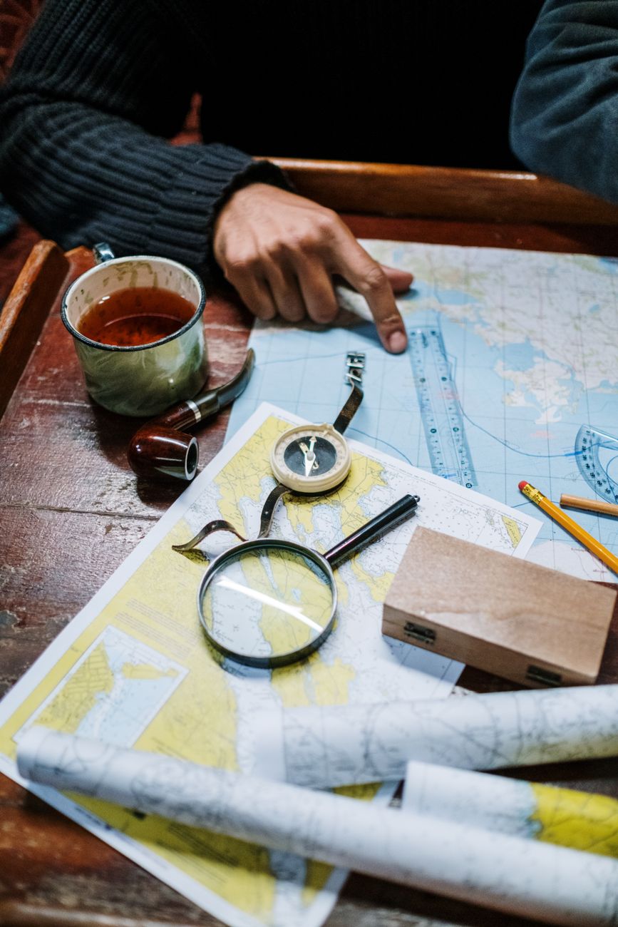 A traveler reviewing a paper map over artisanal coffee